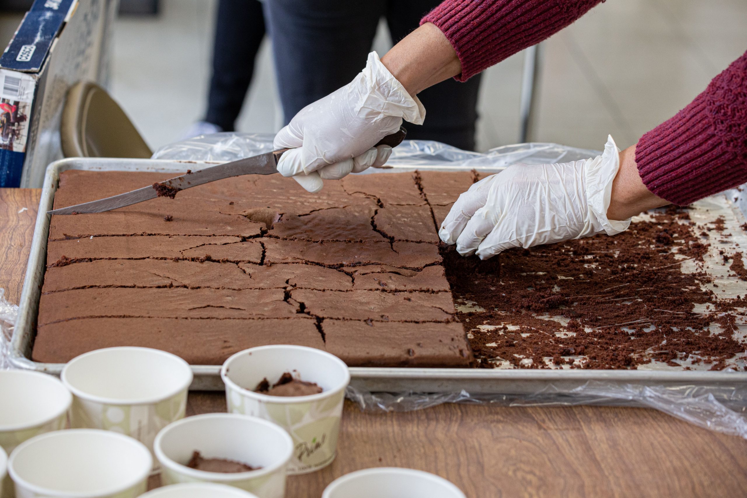 Volunteer cutting up brownies