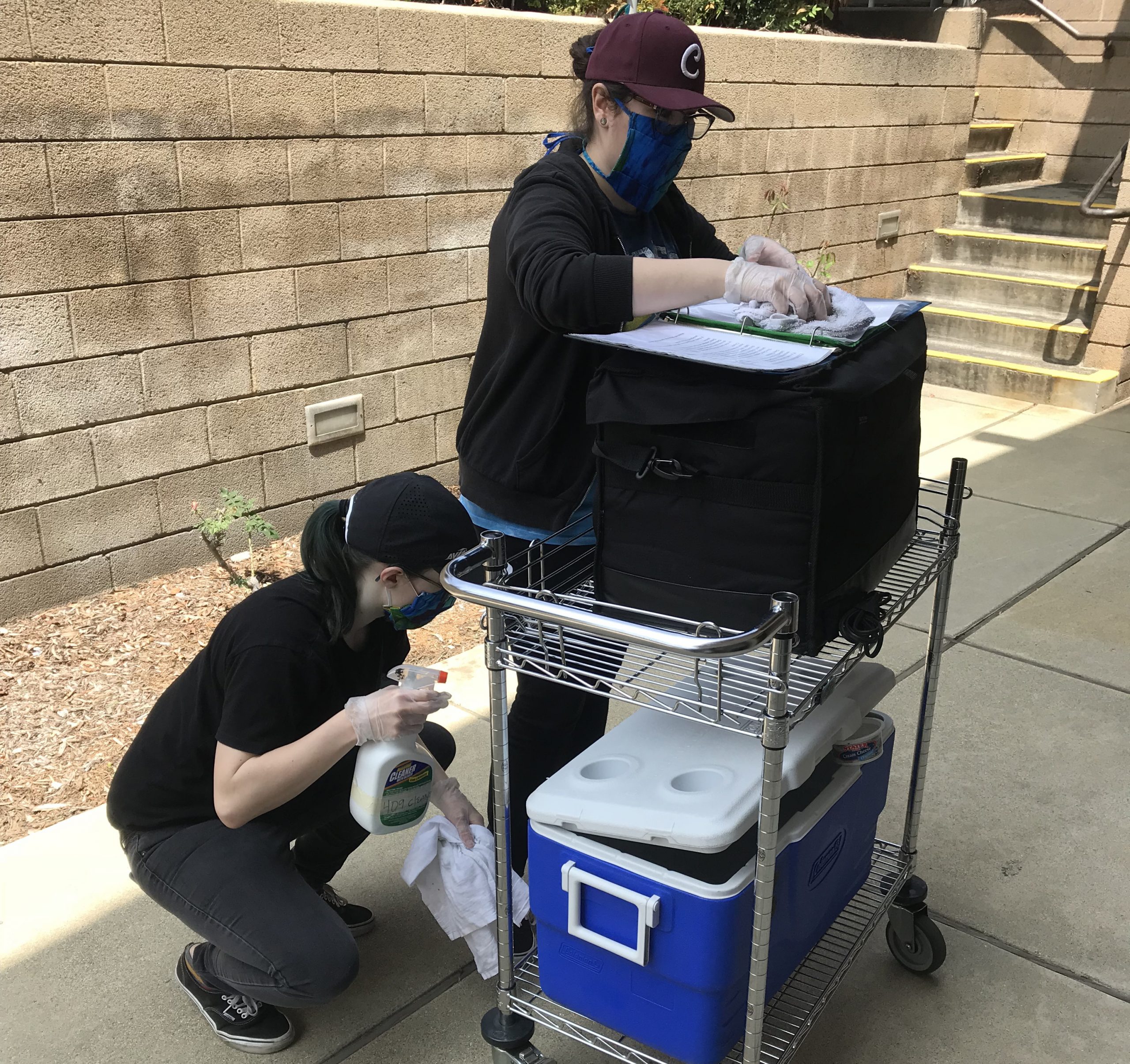 Volunteers sanitizing cooler and bag