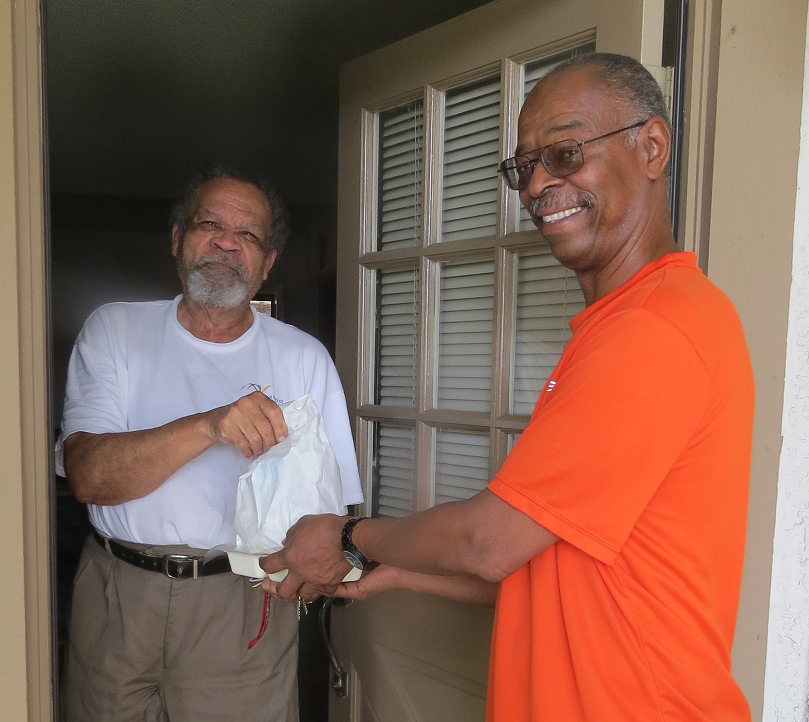 Image of volunteer handing a client a meal