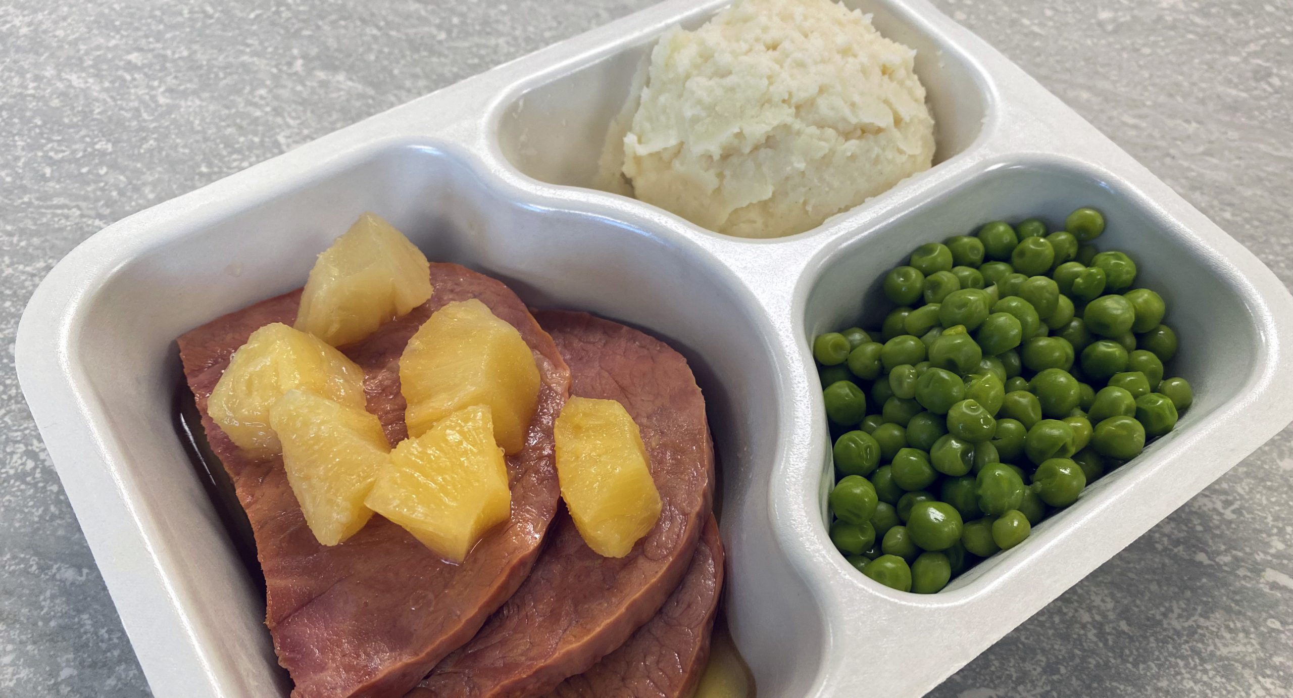 Ham with pineapple, peas, and mashed potatoes