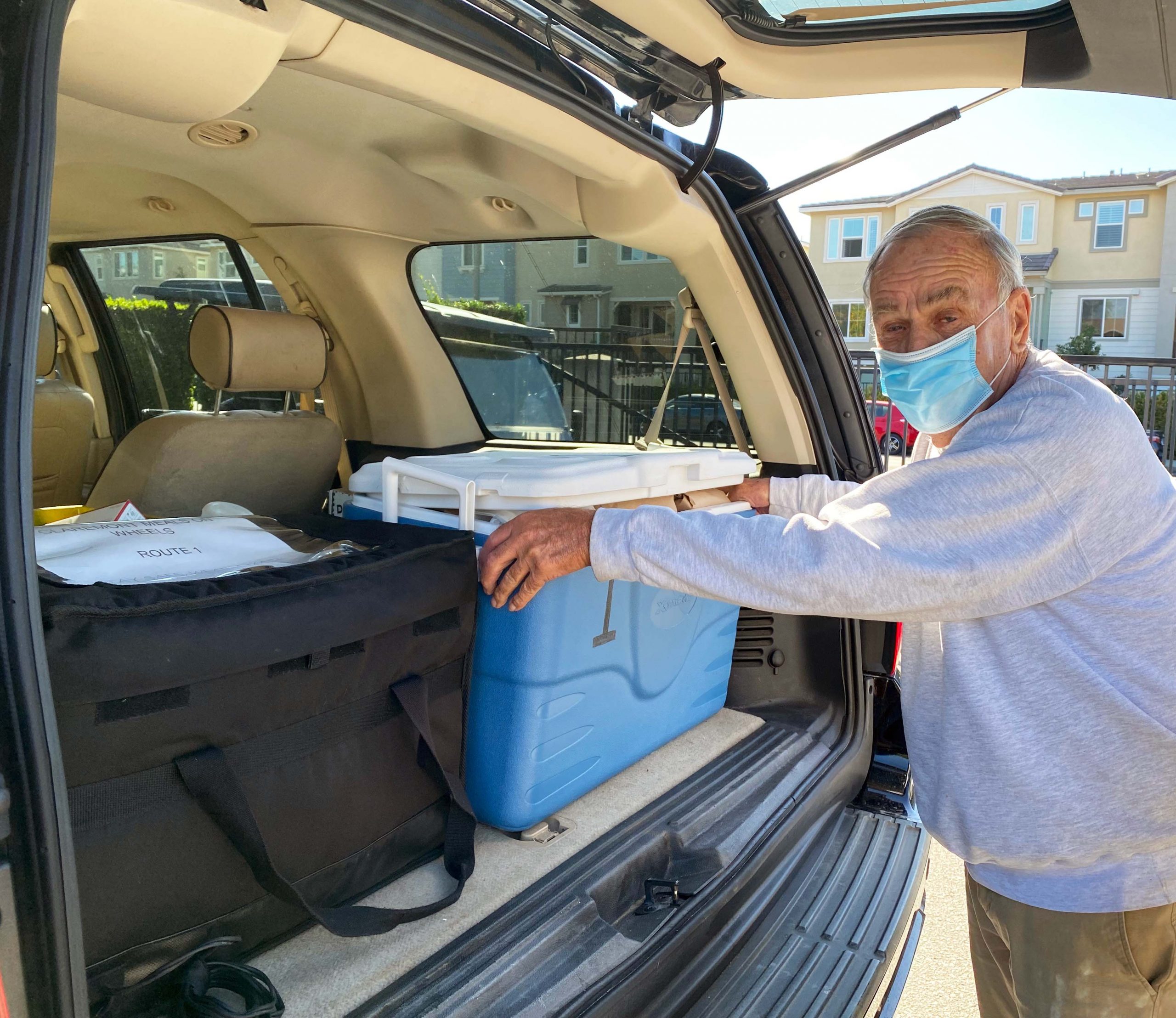 Volunteer packing meals into their car for delivery